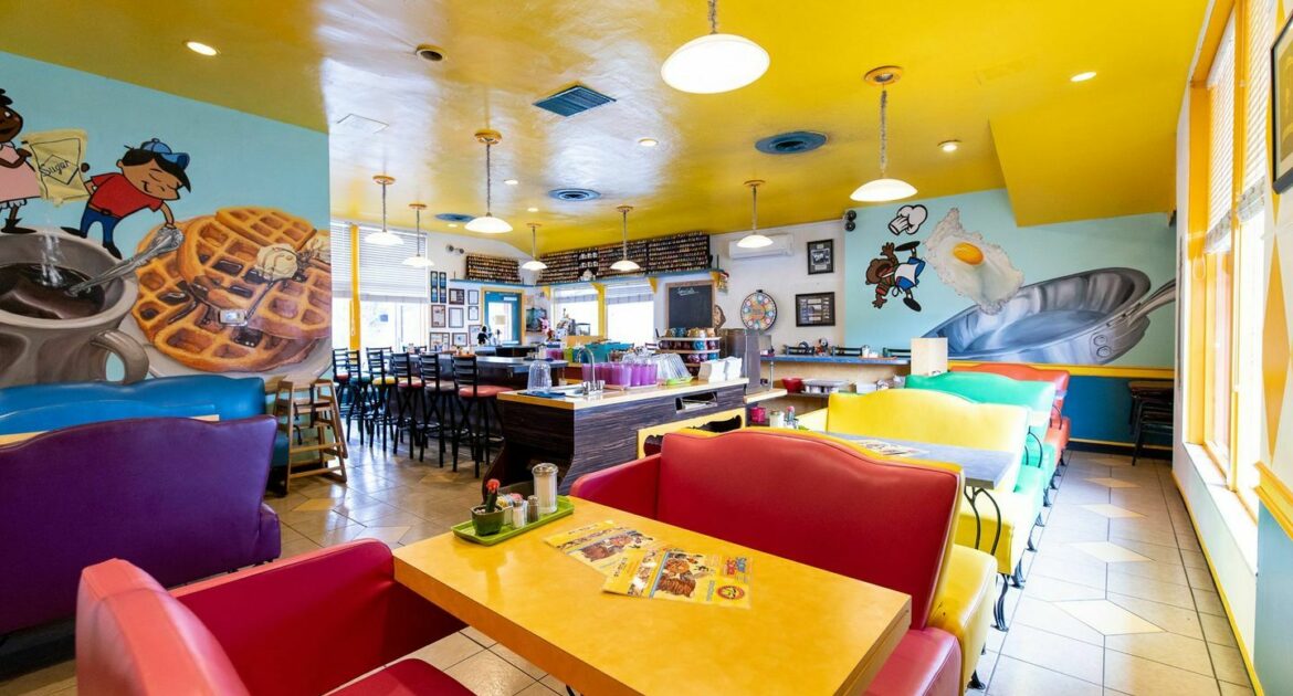 Inside Sugar n Spice restaurant, featuring colorful furniture and oversized pictures of animated characters and breakfast food on the walls.